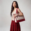 Model carrying the Boutique Canvas Tote with maroon trim over her shoulder