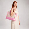 Model carrying the Boutique Canvas Tote with pink trim on her forearm